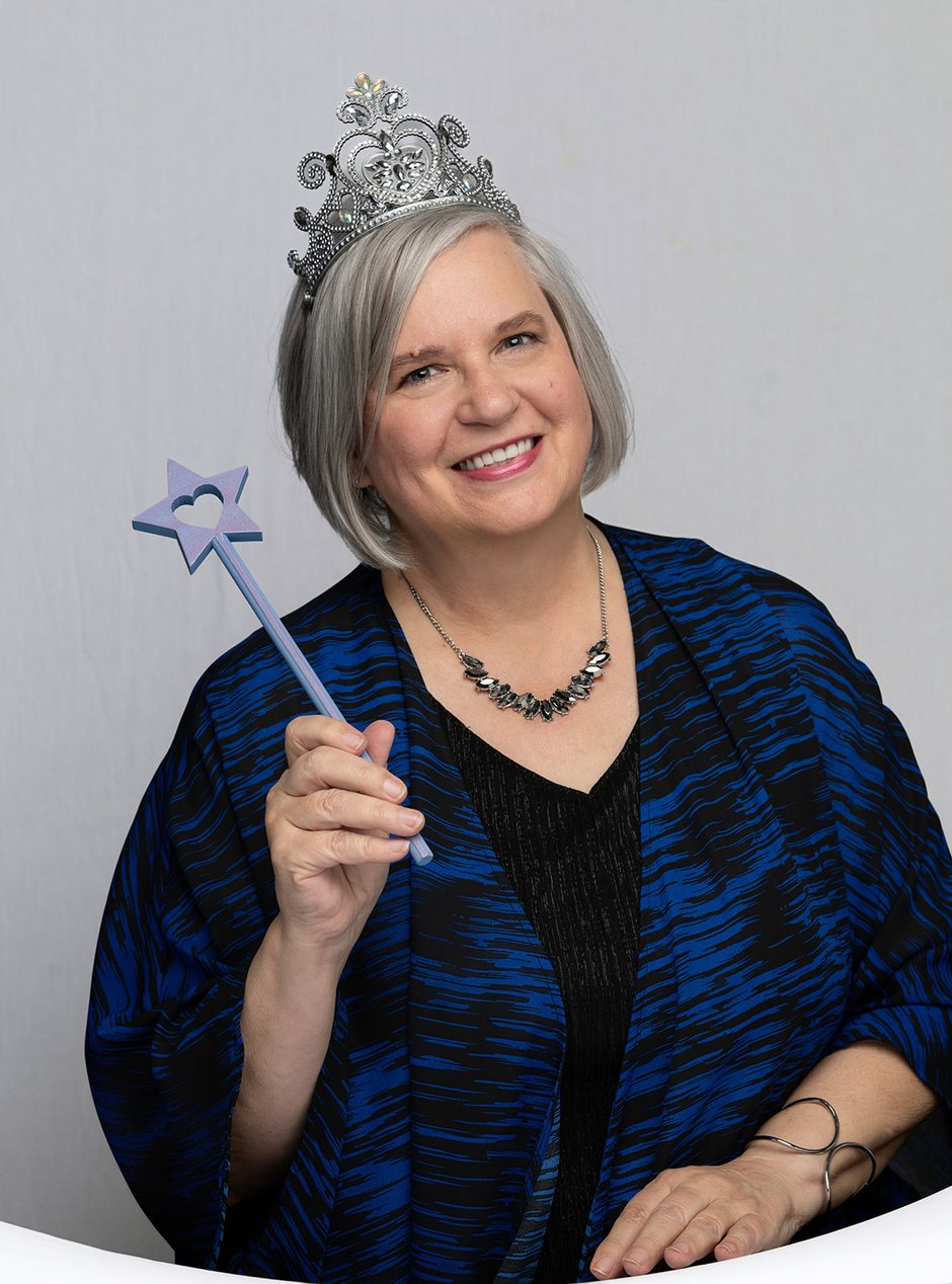 Rita Thomas, your Funnel Godmother, smiling in her crown and holding her wand